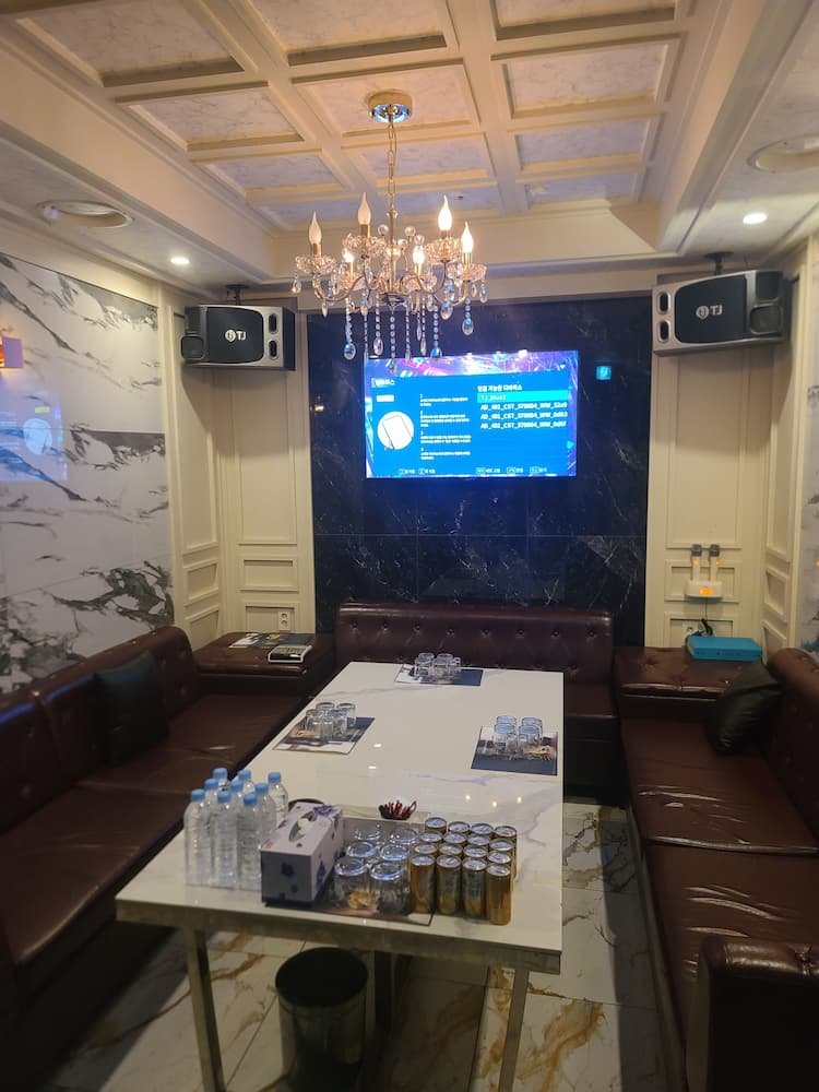 강남블랙홀 룸 — ㄷ자 브라운 가죽 소파와 화이트 대리석 테이블